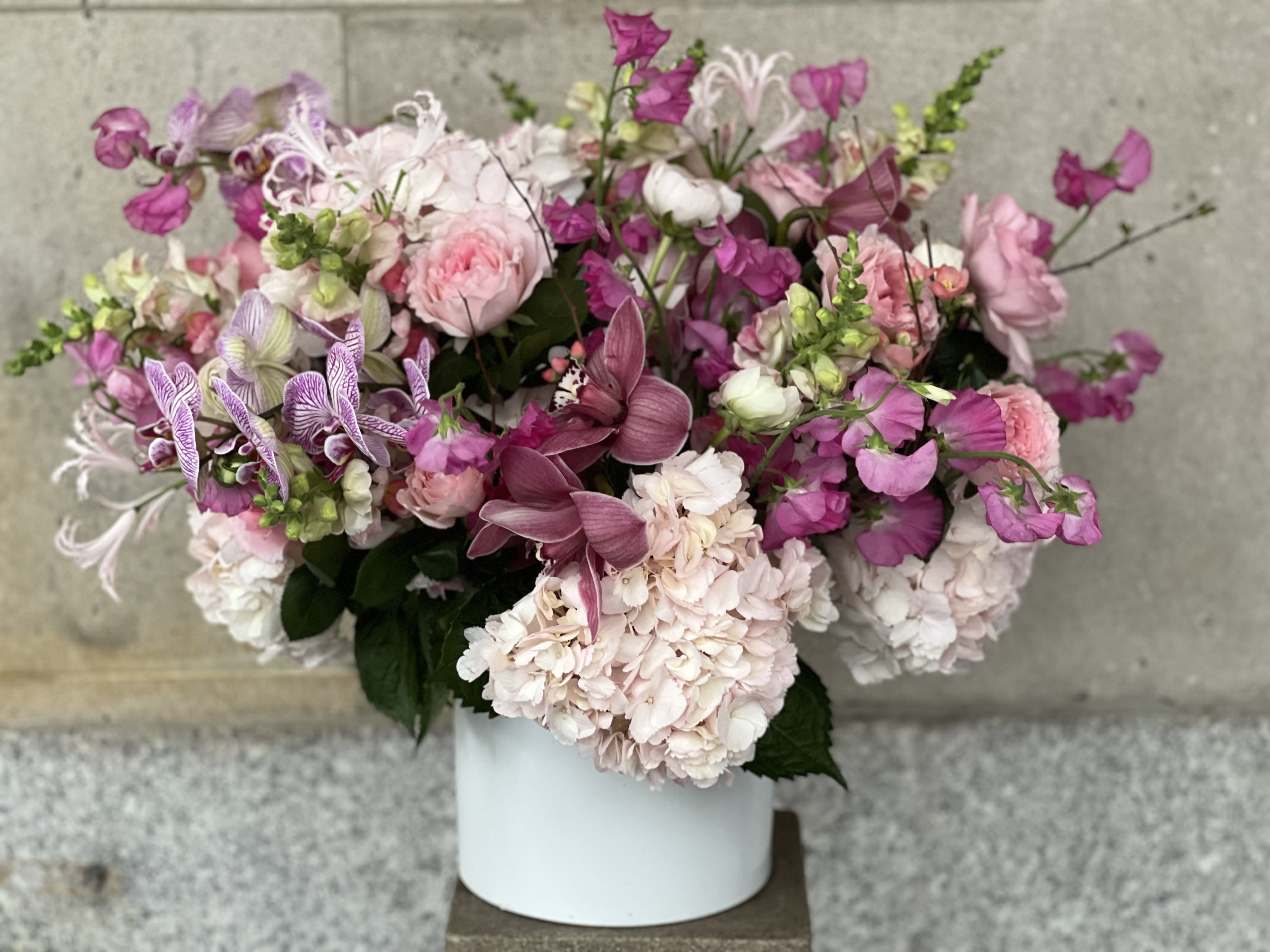 Pink and white mixed flower arrangement in a white vase