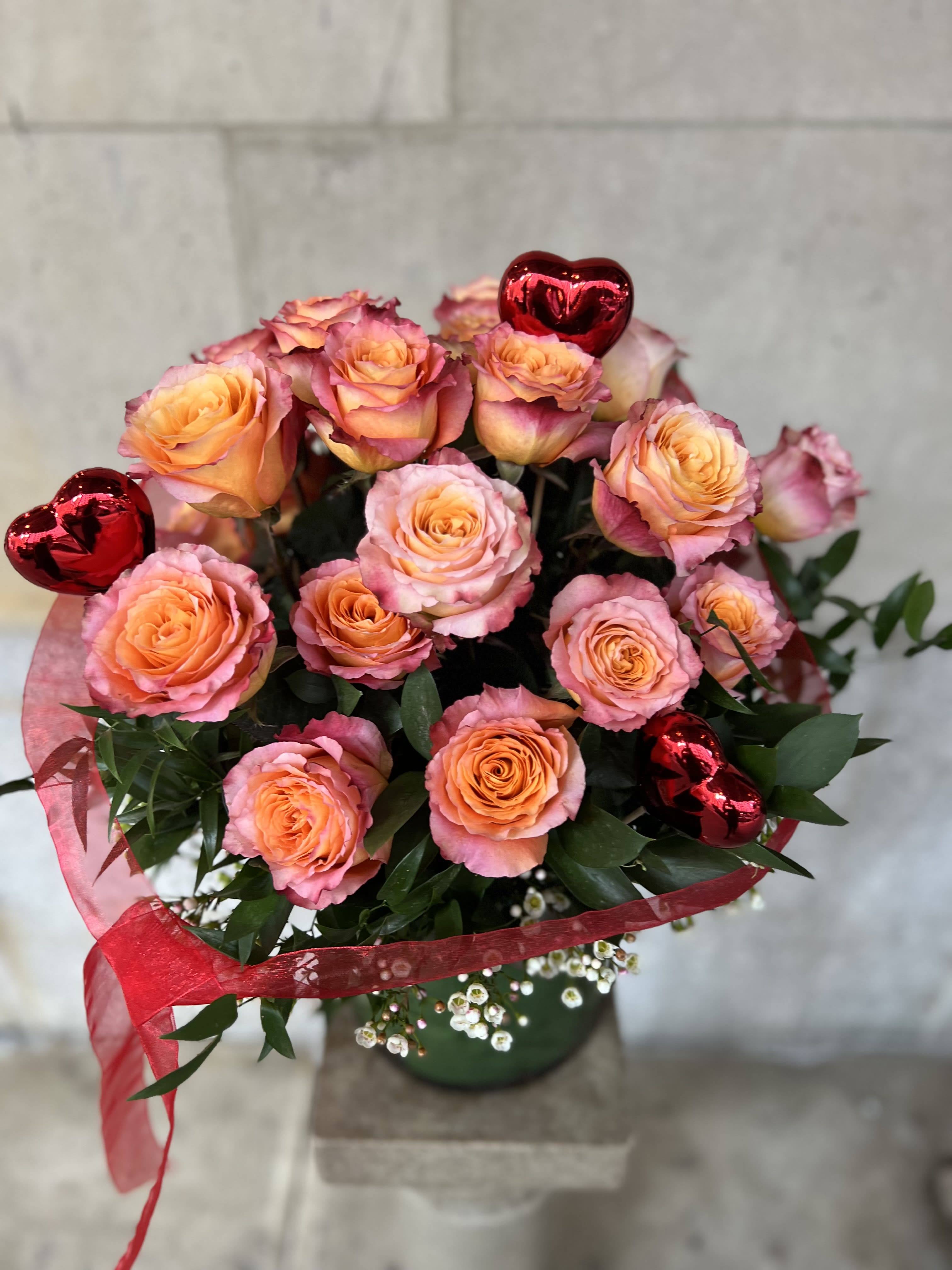 SWEETHEART 4  / ORANGE ROSES - We are pleased to highlight our exquisite collection of long-stemmed roses, expertly arranged by Flowers by Philip. These classic arrangements, accented with seasonal foliage, are available in three stunning options:  * **Standard Version:** Dozen long-stemmed roses  * **Deluxe Version:** Dozen and a half long-stemmed roses  * **Premium Version:** Two dozen long-stemmed roses   For a truly unforgettable gift, choose the timeless elegance of long-stemmed roses by Flowers by Philip.