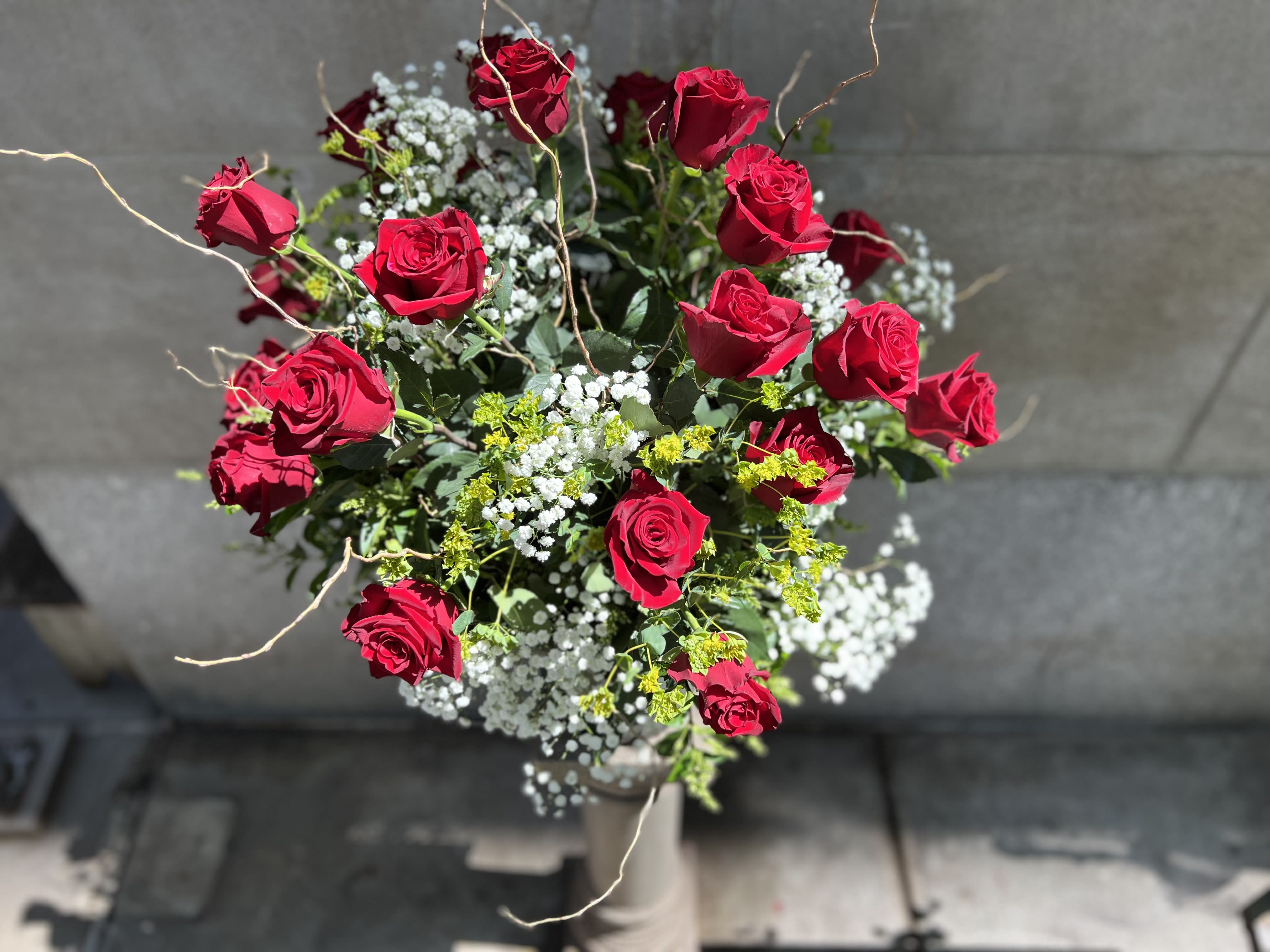 24  LONG STEM RED ROSES  - We are pleased to highlight our exquisite collection of long-stemmed roses, expertly arranged by Flowers by Philip. These classic arrangements, accented with seasonal foliage, are available in three stunning options:   * **Premium Version:** Two dozen long-stemmed roses   For a truly unforgettable gift, choose the timeless elegance of long-stemmed roses by Flowers by Philip. 