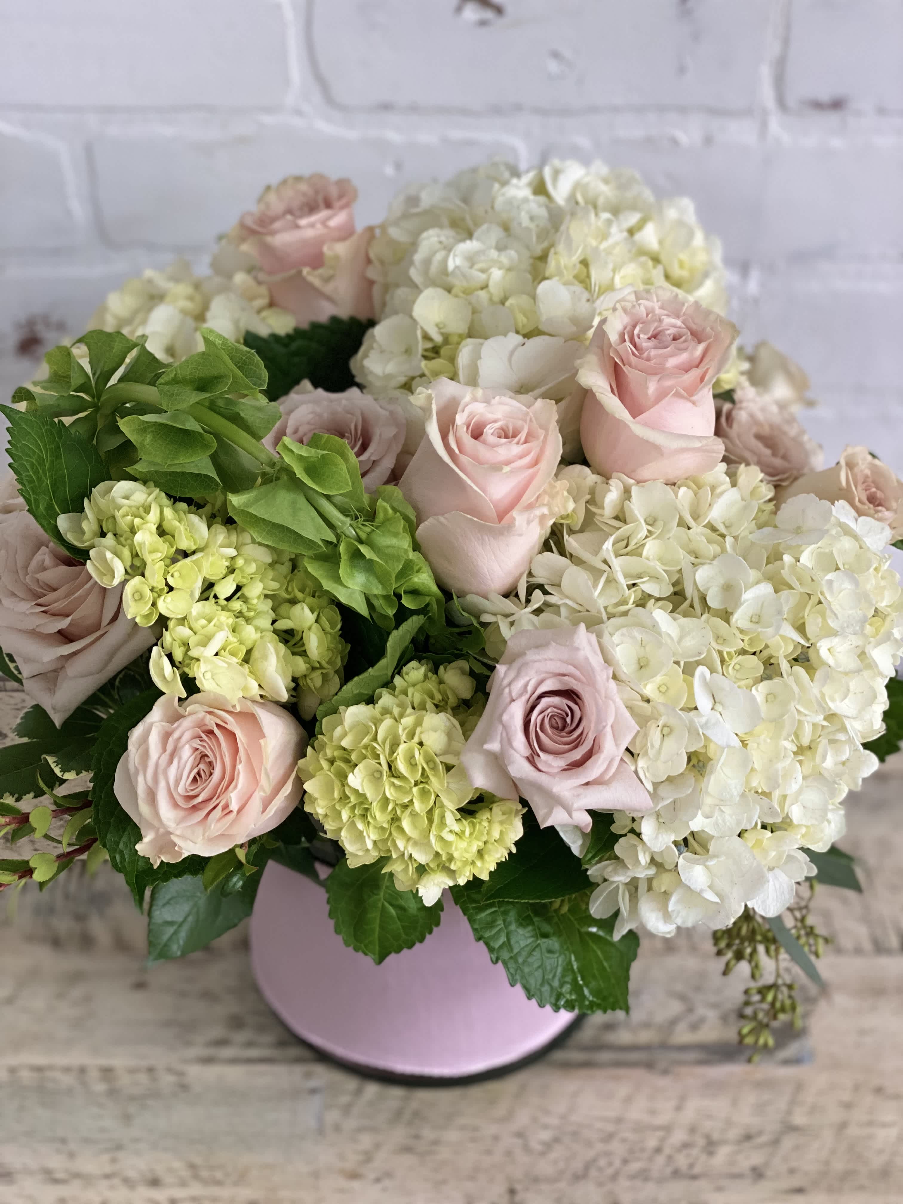 Sweetheart - Cylinder vase wrapped with pink ribbon, filled with hydrangeas and a dozen roses. Perfect for someone sweet!