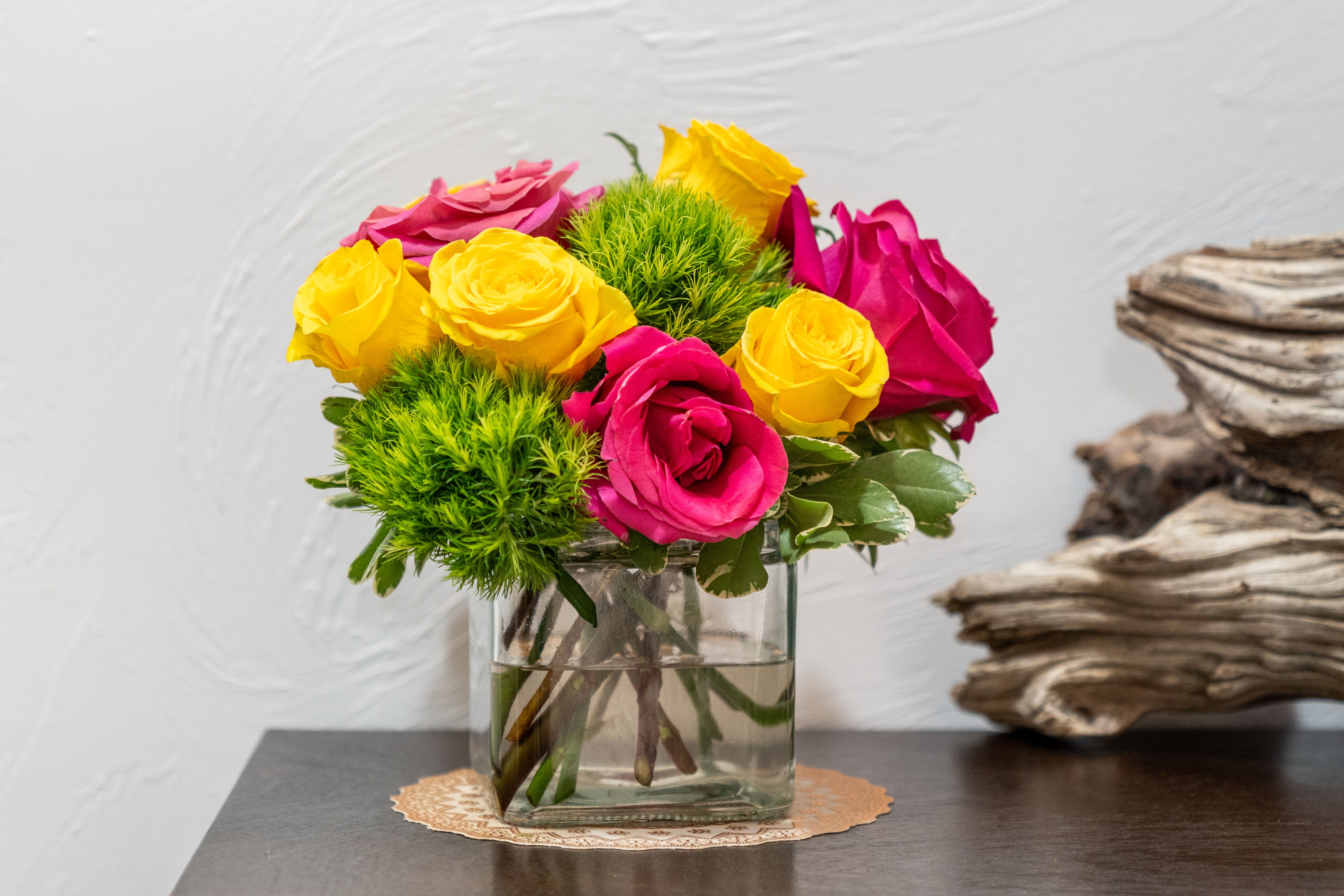 Pink and yellow roses in a clear glass vase