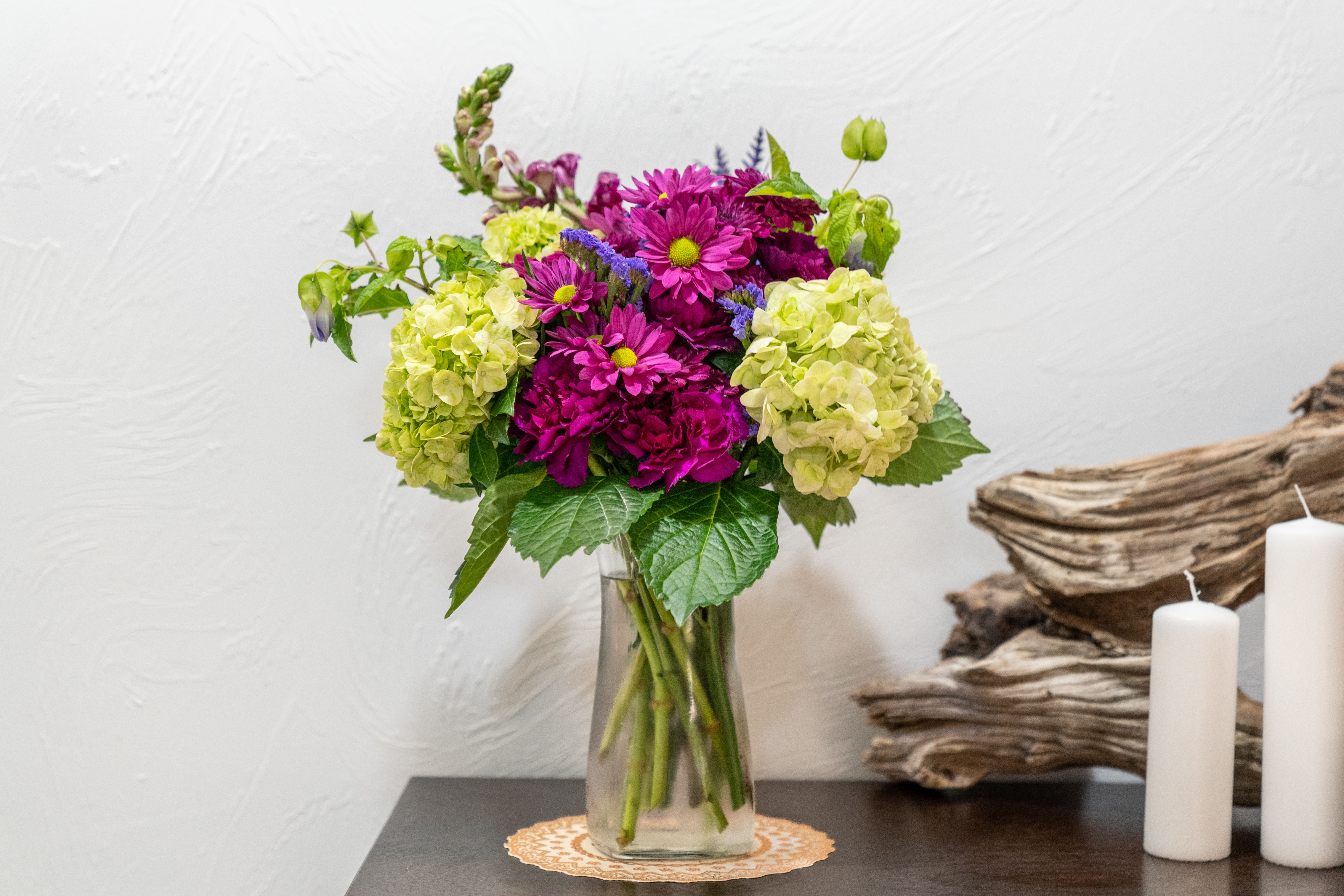 Magenta and lime hydrangea bouquet in a clear glass vase