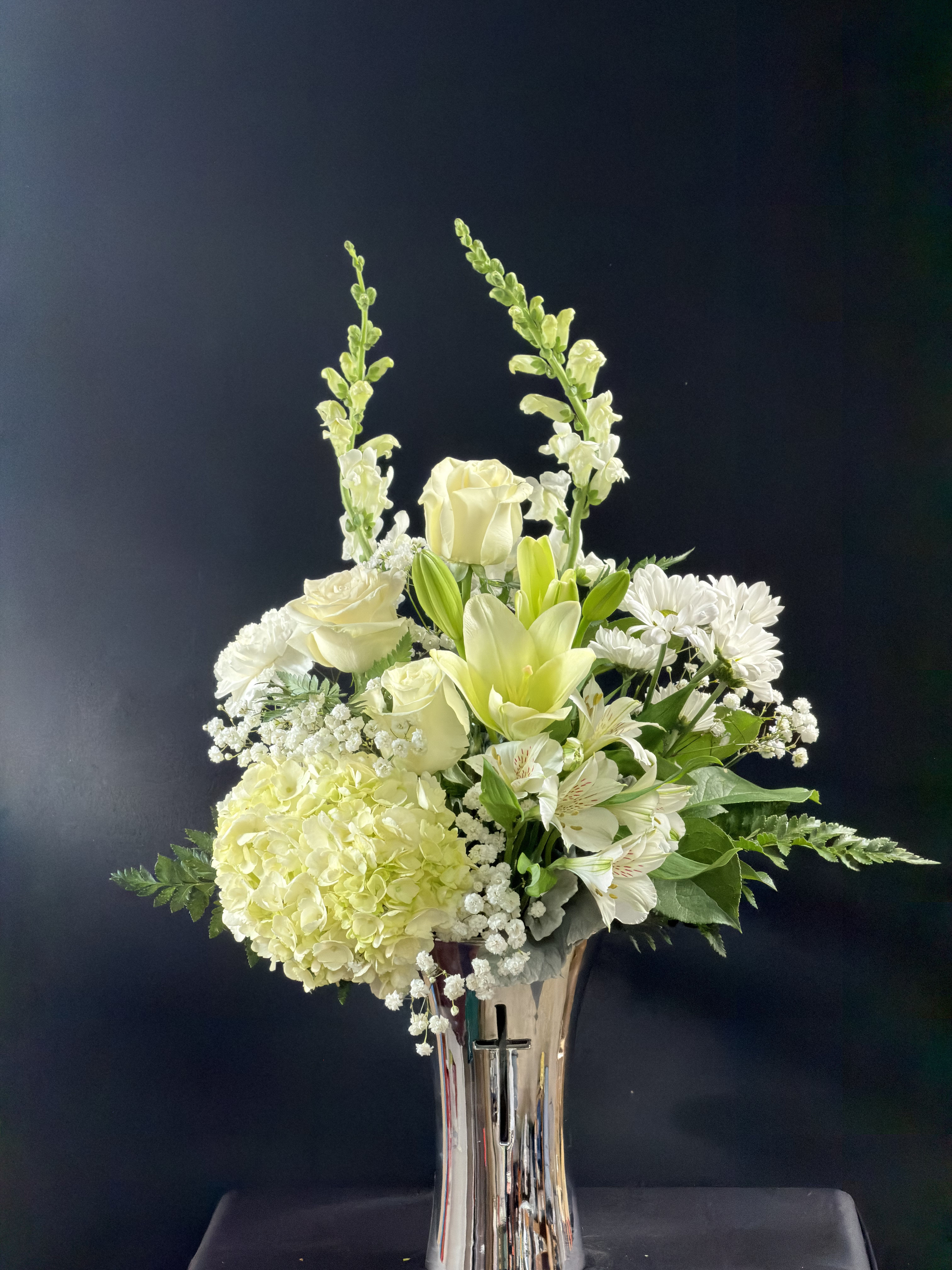 White floral arrangement in a tall silver vase