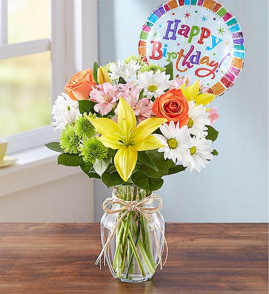 Mixed bouquet in a glass jar with a birthday balloon