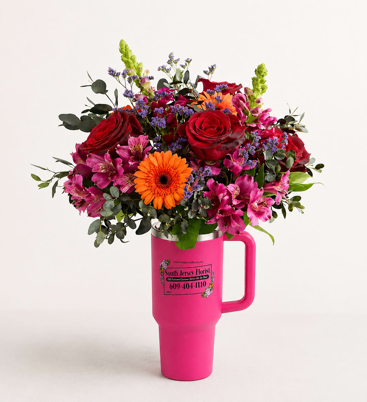 Pink Pick-Me-Up - Brighten someone's day with a gift that's as fun as it is beautiful! Our Pink Pick-Me-Up features a vibrant mix of premium blooms including rich red roses, cheerful gerbera daisies, alstroemeria, snapdragons, statice, and fresh greenery, all artfully arranged in a reusable hot pink handled tumbler. Perfect for birthdays, thank yous, get well wishes, or "just because," this unique gift keeps giving long after the flowers have faded. Once the blooms are enjoyed, the insulated tumbler is ready to become an everyday favorite for coffee, water, or any beverage on the go.  Flower varieties may vary slightly based on seasonal availability while maintaining the overall color palette and style.