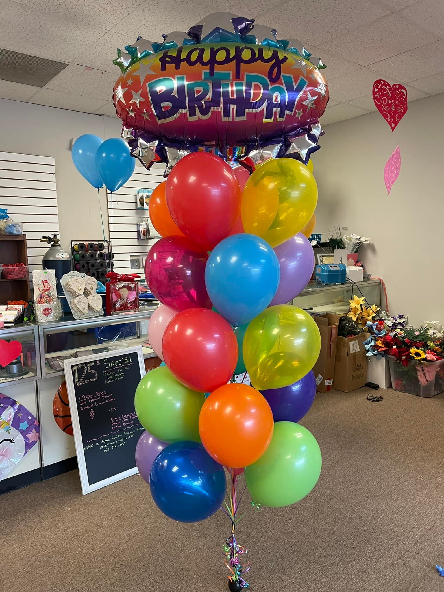 A large birthday balloon bouquet with a "Happy Birthday" foil balloon