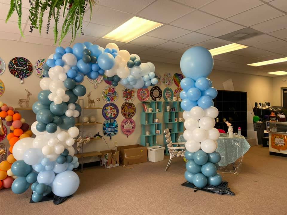 Blue and white balloon arch in a party room