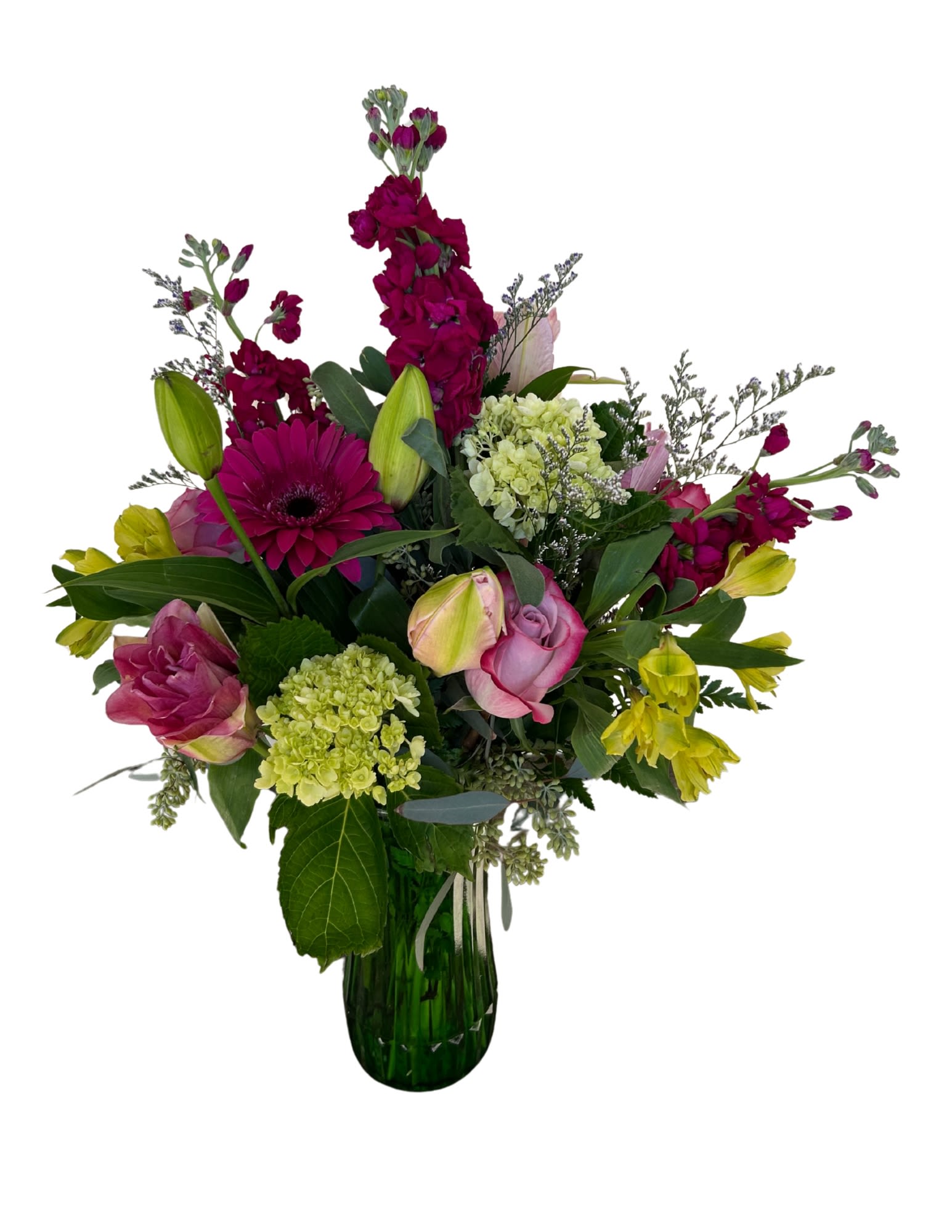 Mixed bouquet of pink, yellow, and green flowers in a glass vase