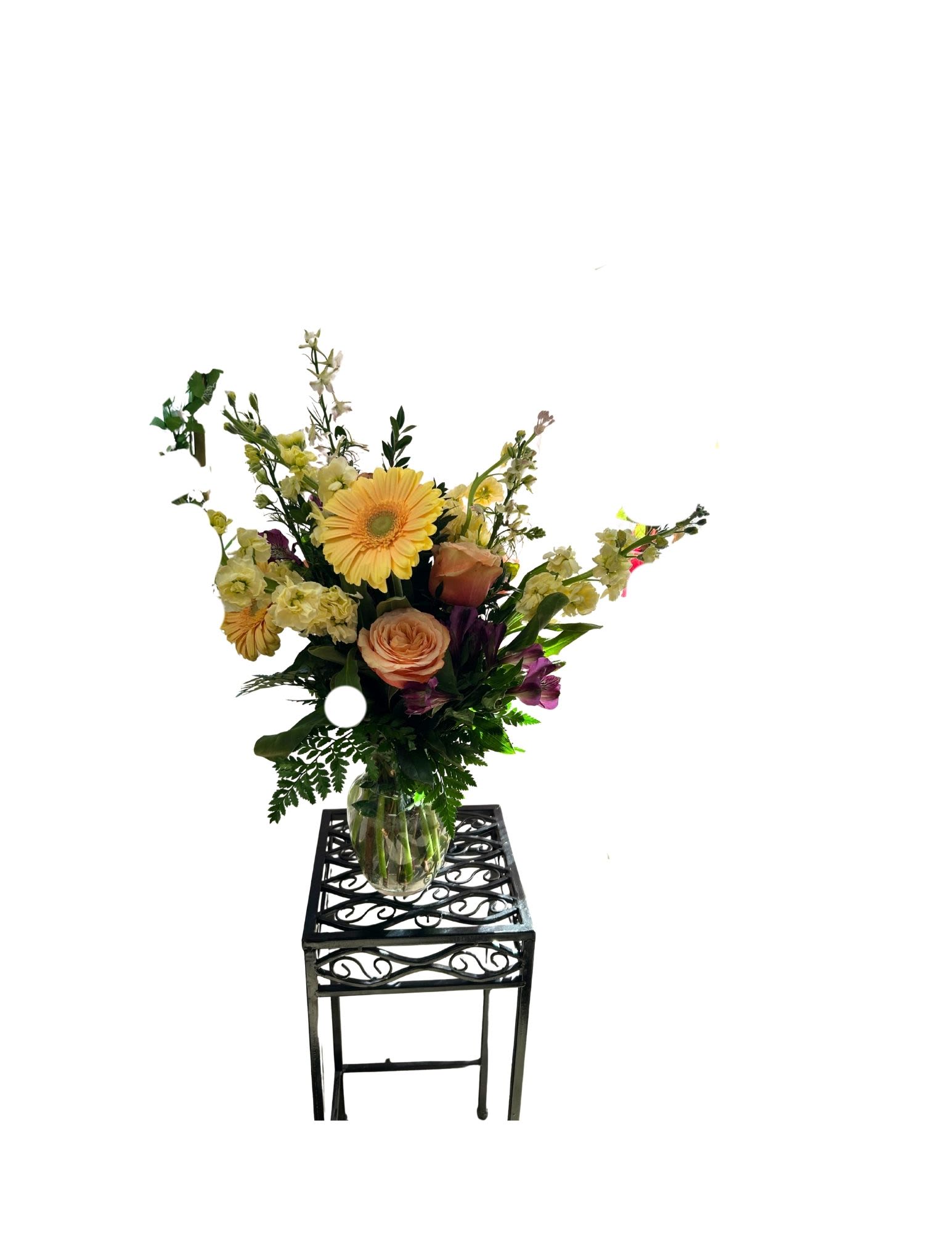 Mixed bouquet in a glass vase on a decorative black stand