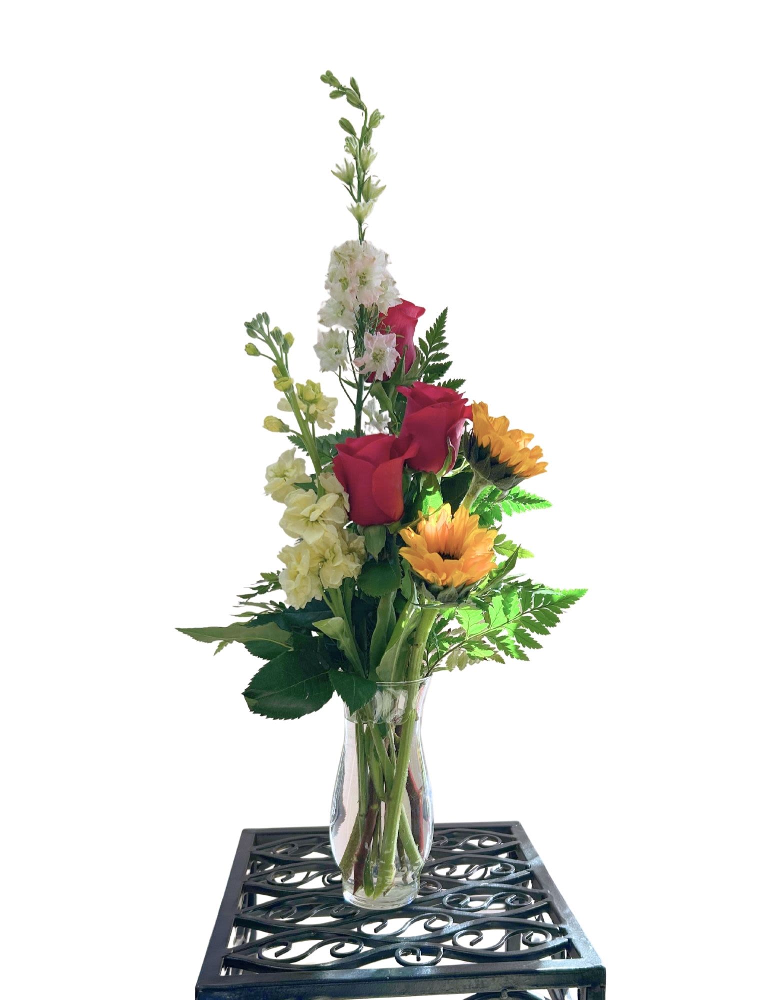 Mixed bouquet in a clear glass vase with red roses and yellow sunflowers