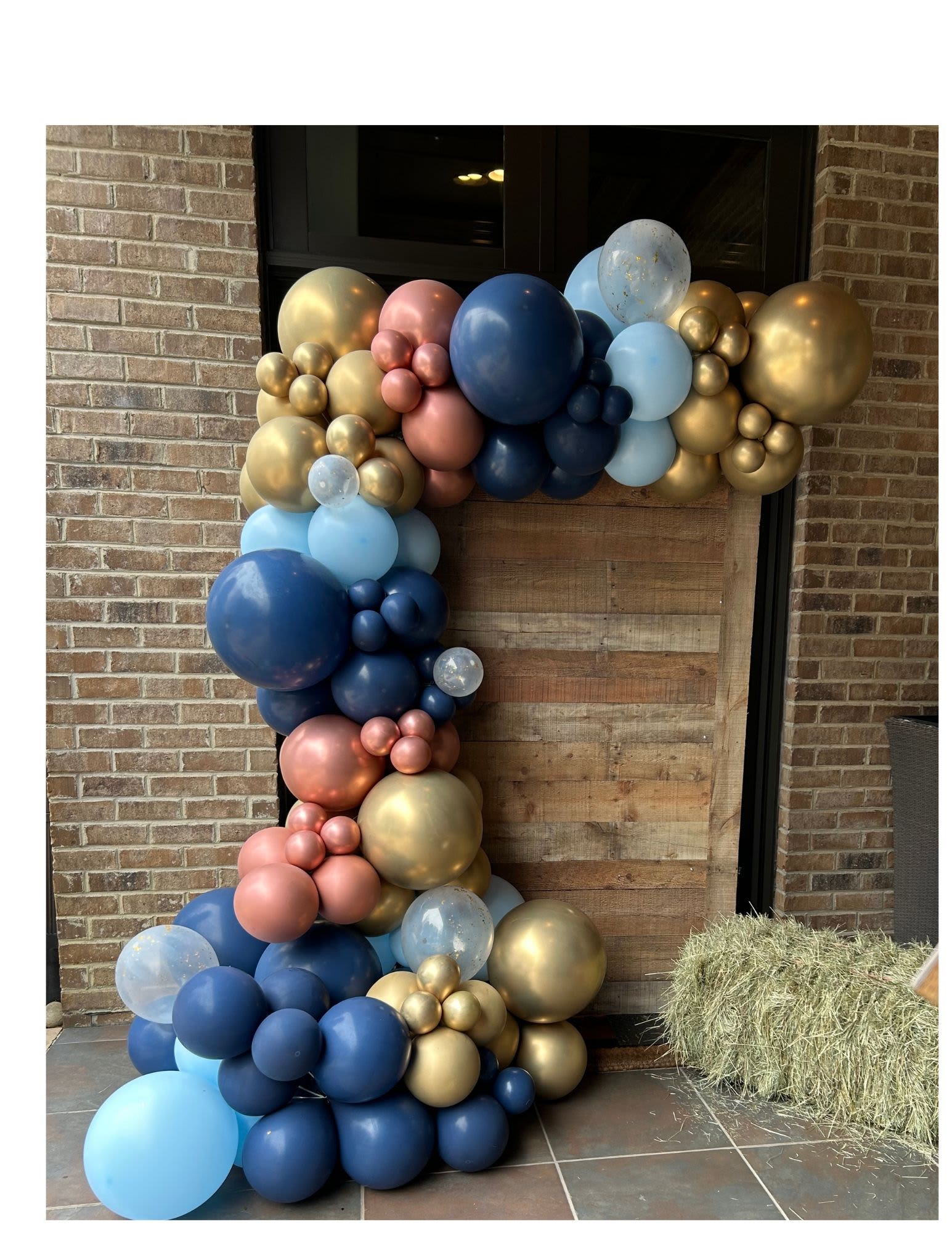 Large balloon garland in blue, gold, pink, and clear balloons