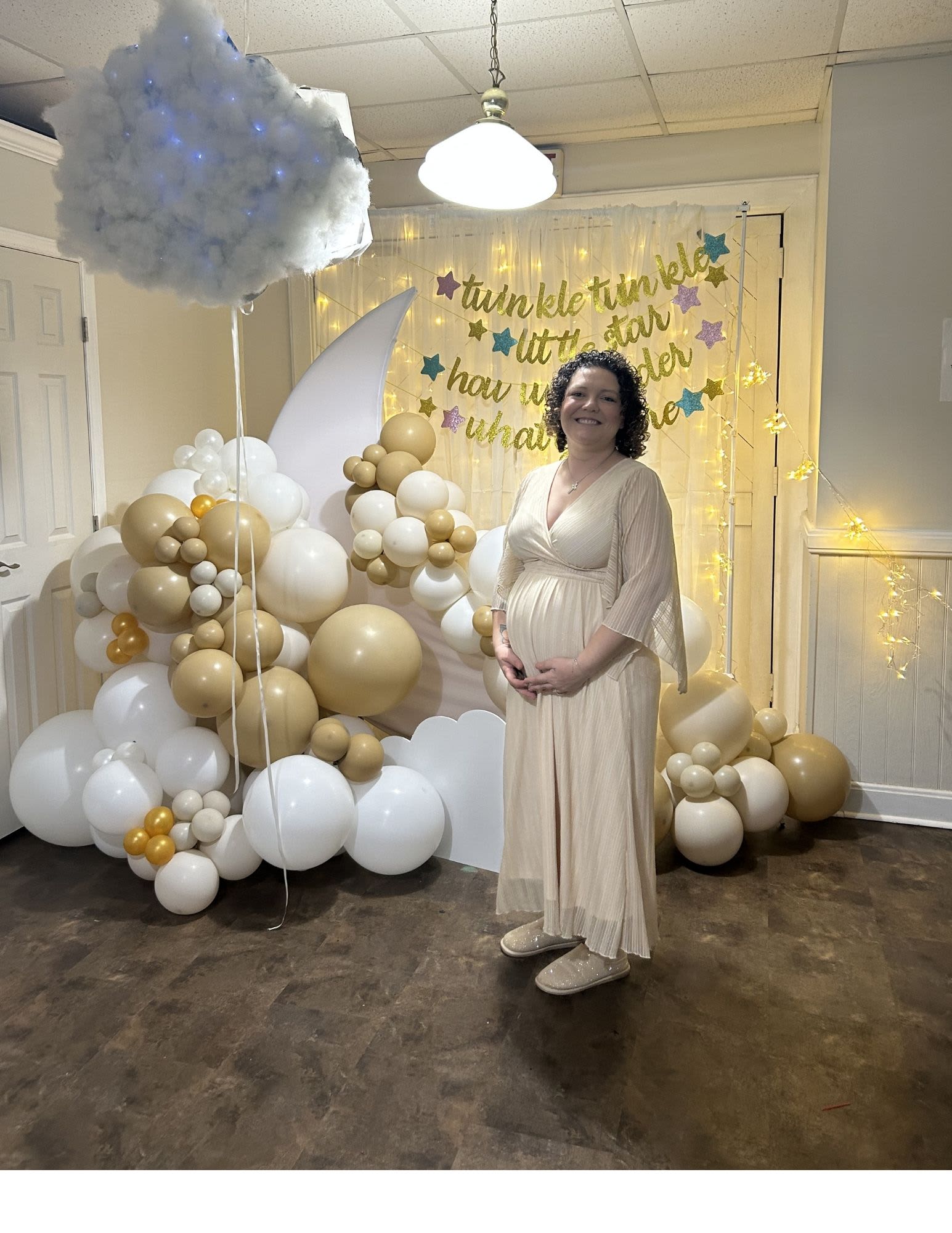 Gold and white balloon display with a cloud and moon backdrop