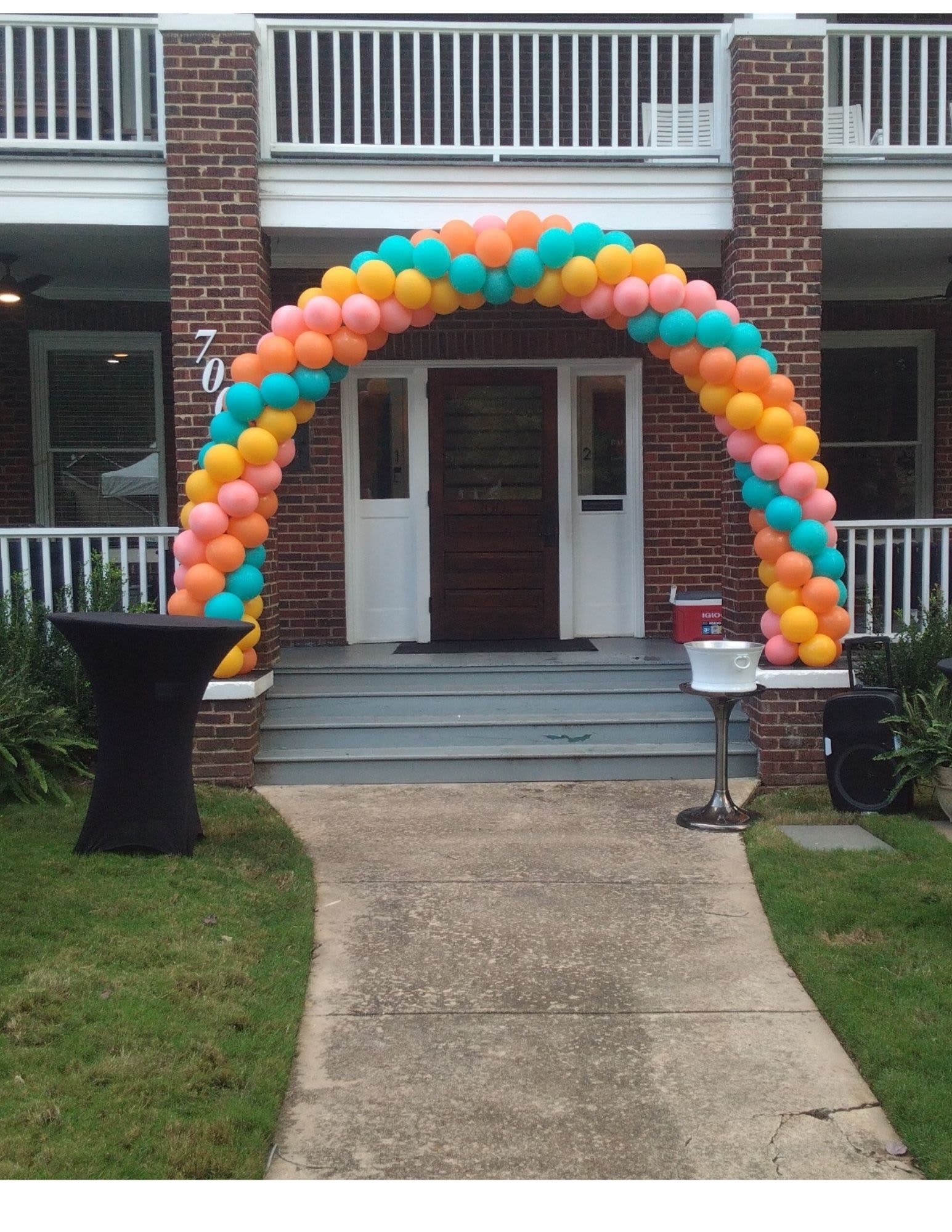 Colorful balloon arch framing a house entrance