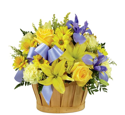 Yellow and purple flower arrangement in a wooden basket with ribbon