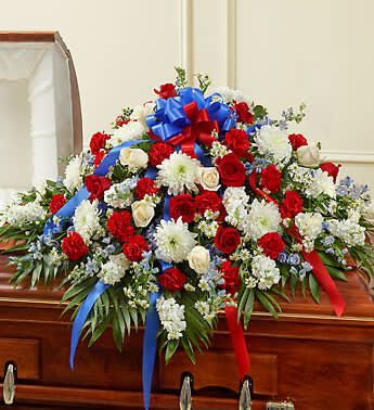  Red, White &amp; Blue  Half Casket Cover - A beloved family member who has served his or her country deserves a beautiful and fitting final tribute. Commemorate the patriotism and bravery they displayed with this half casket cover, crafted with care and artistry by our expert florists. It features gorgeous red, white and blue flowers to honor them in an unforgettable way.Half casket cover arrangement of fresh red, white and blue flowers such as roses, cremones, blue delphinium, carnations and more