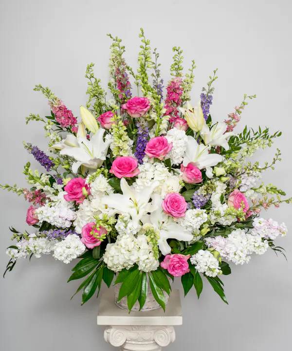 Our elegant pink and white standing basket  - For those who are grieving, a heartfelt gesture can mean so much. Our elegant pink and white standing basket arrangement will honor the memory of a loved one in a beautiful way. Artistically designed with a medley of pink blooms, this touching expression offers comfort and support when it’s needed most.