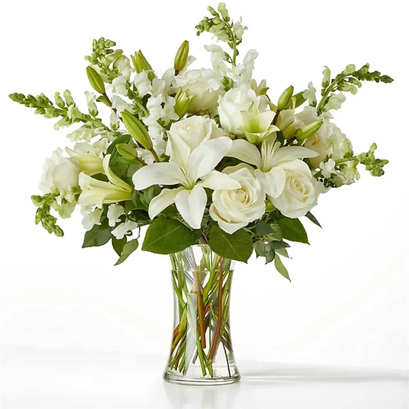 White lilies and roses in a clear glass vase