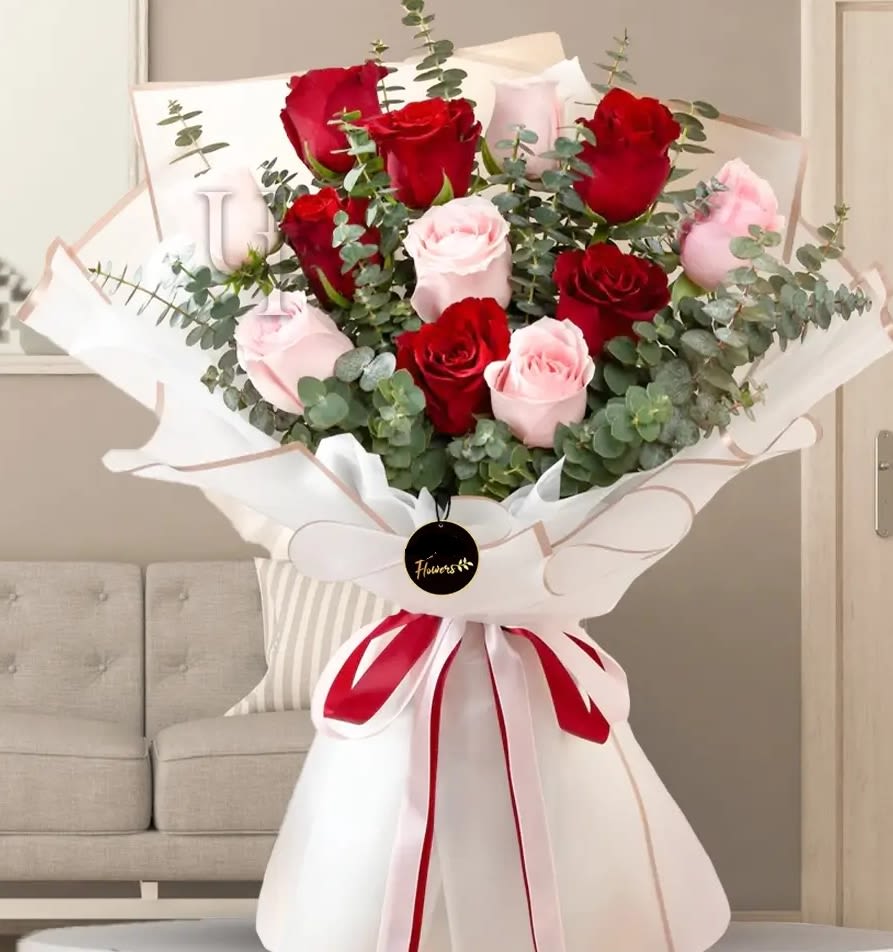 Bouquet of red and pale pink roses wrapped in white paper