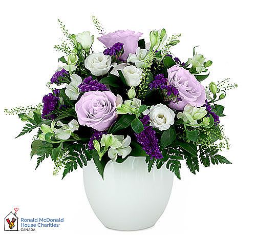Lavender and white roses arranged in a white vase