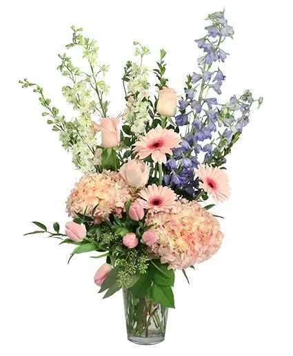 Pink and blue mixed flowers in a clear glass vase