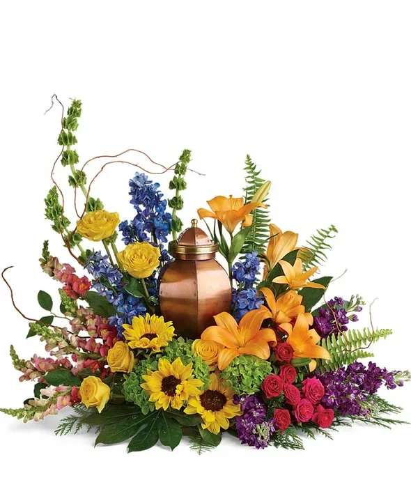 Colorful floral arrangement around a copper urn