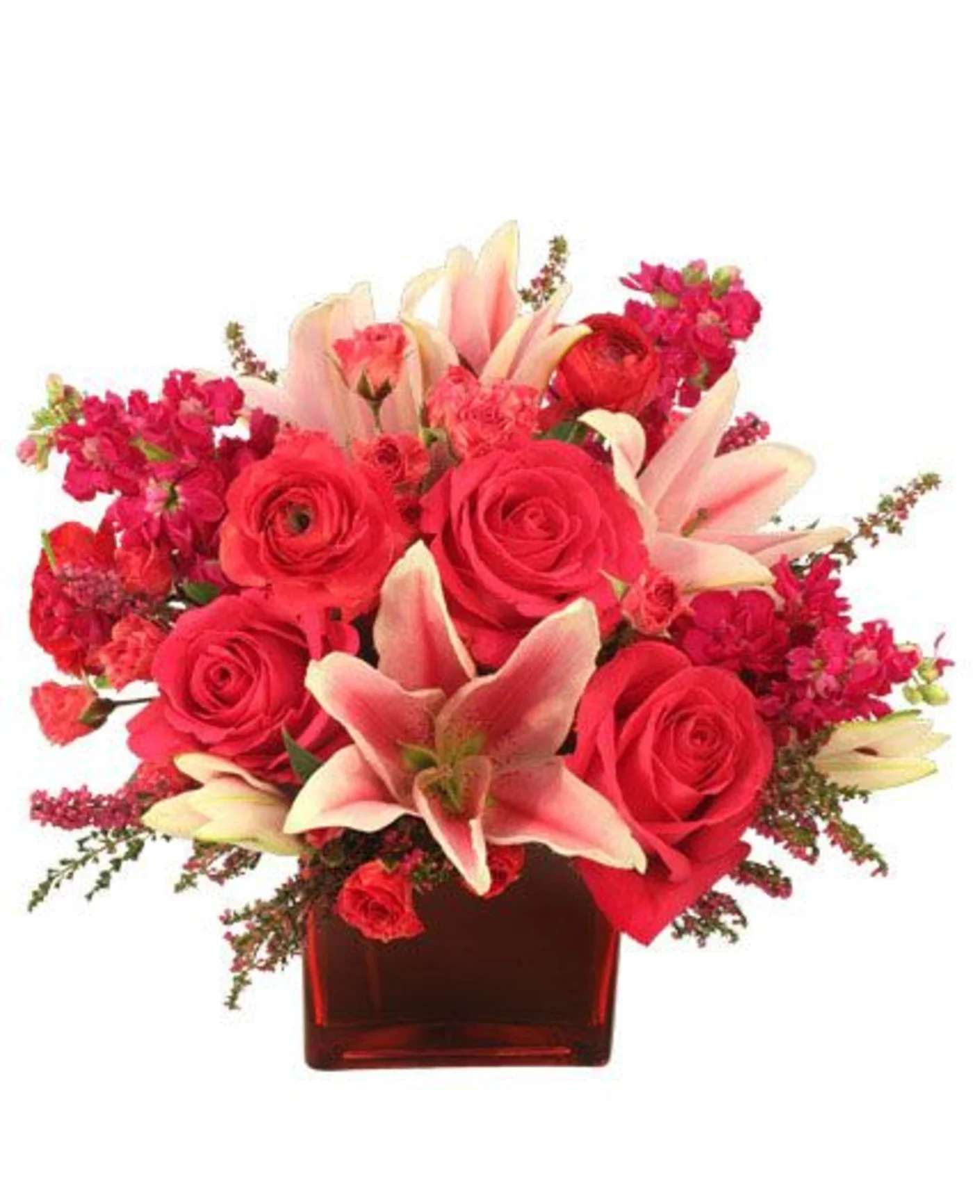 Red roses and pink lilies arranged in a red glass vase
