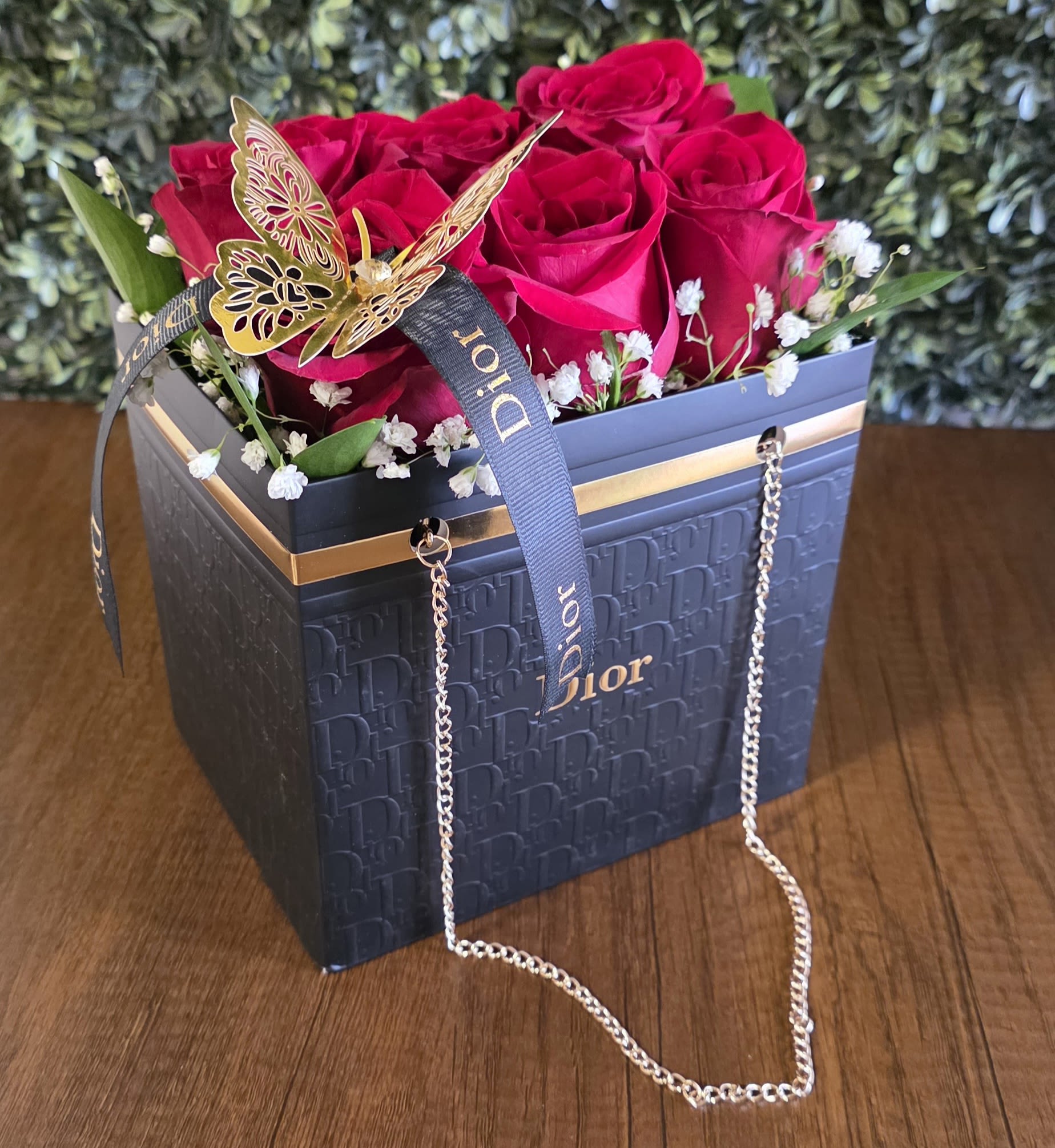 Red roses in a Dior gift box with a butterfly ribbon and chain handle