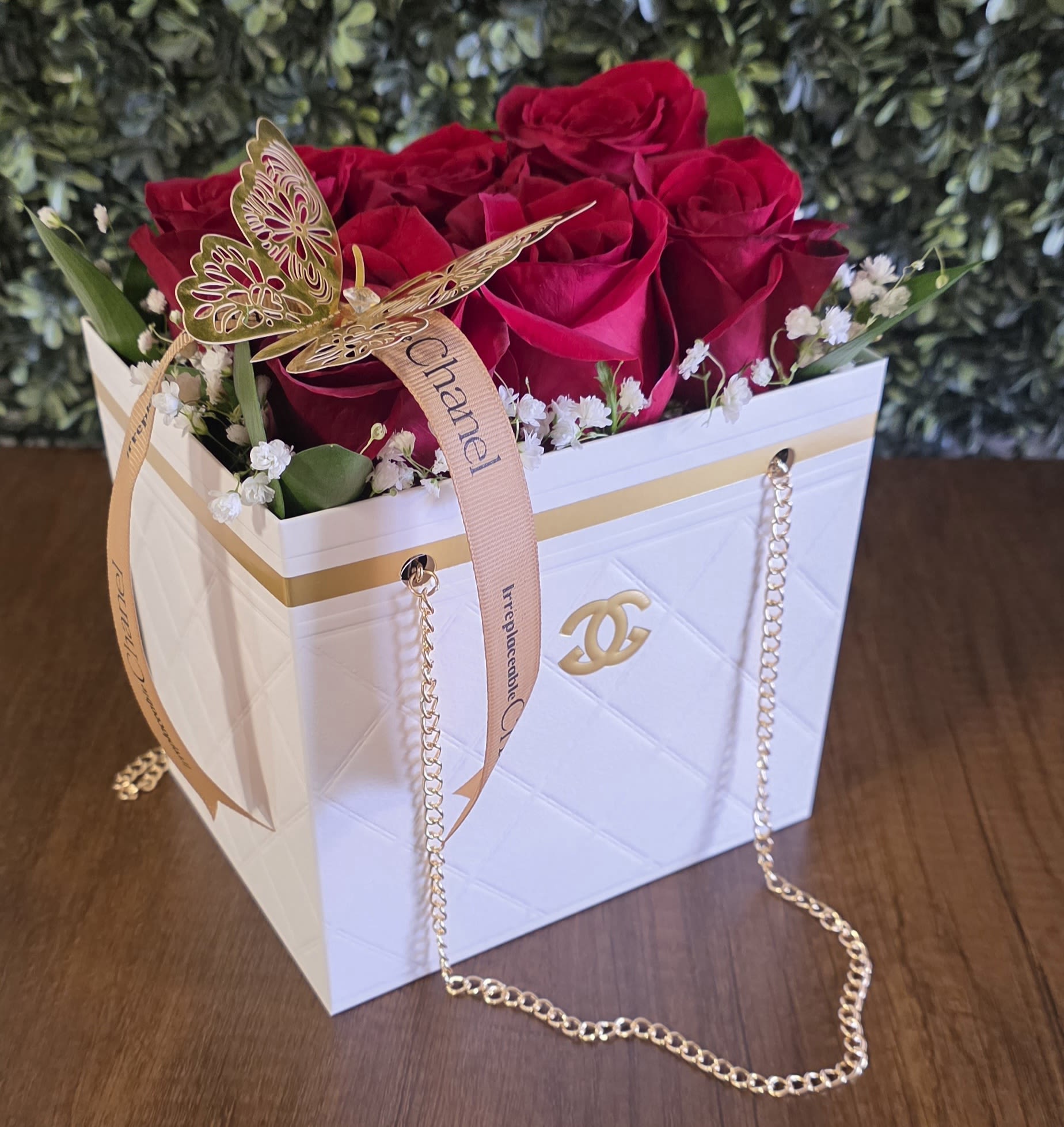 Red roses in a white gift box with a gold butterfly ribbon