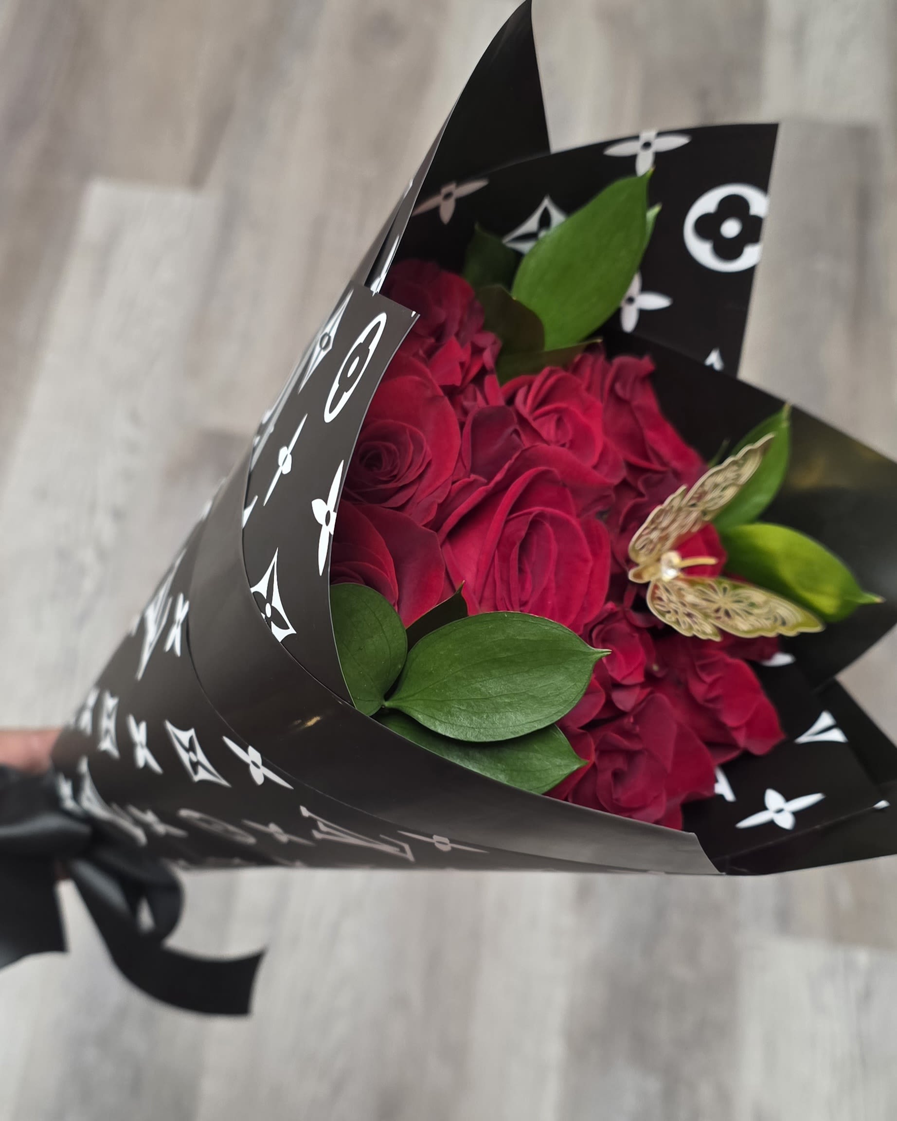 Bouquet of deep pink roses wrapped in black patterned paper