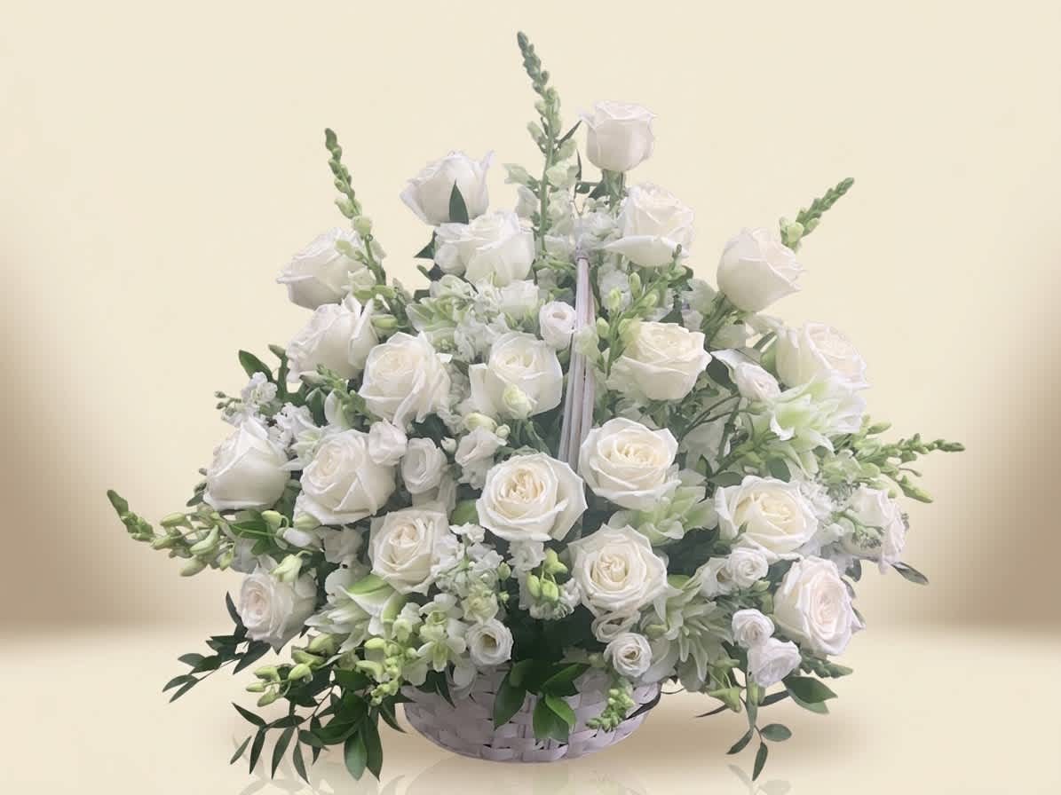 White rose arrangement in a low white basket