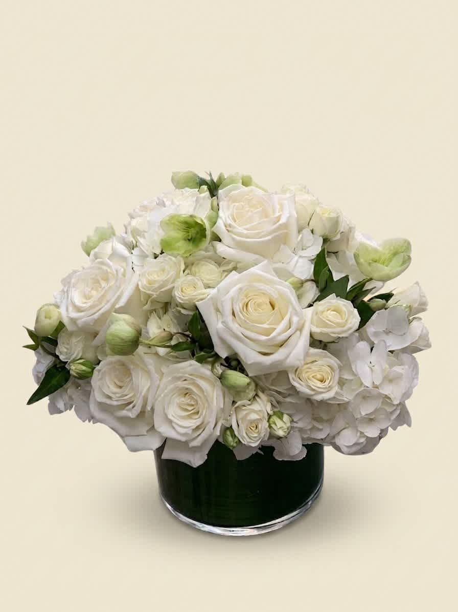 White rose and hydrangea arrangement in a dark glass vase