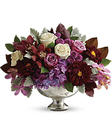 Mixed bouquet of roses and purple flowers in a silver pedestal vase