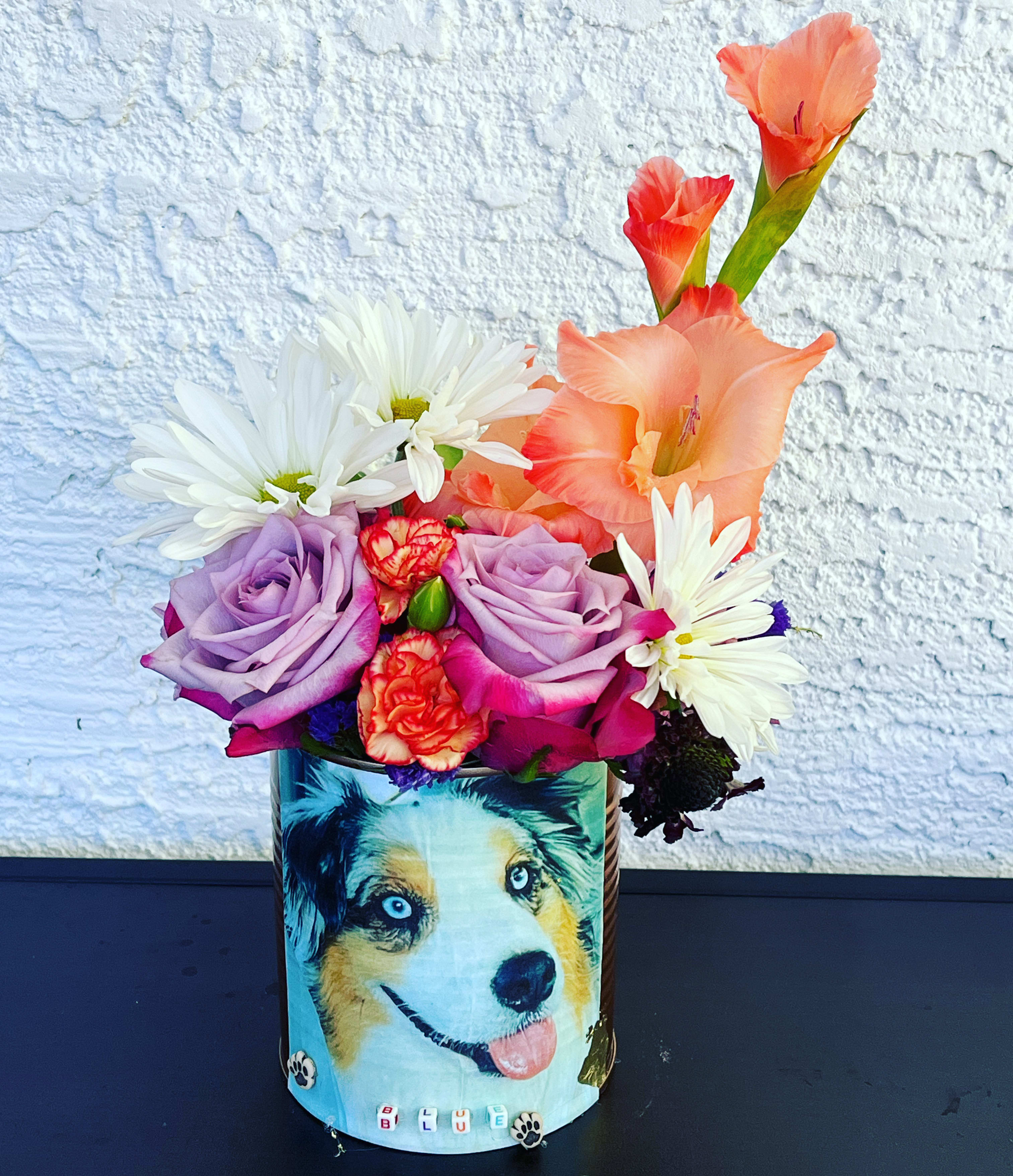 Colorful bouquet in a decorated tin with a dog illustration