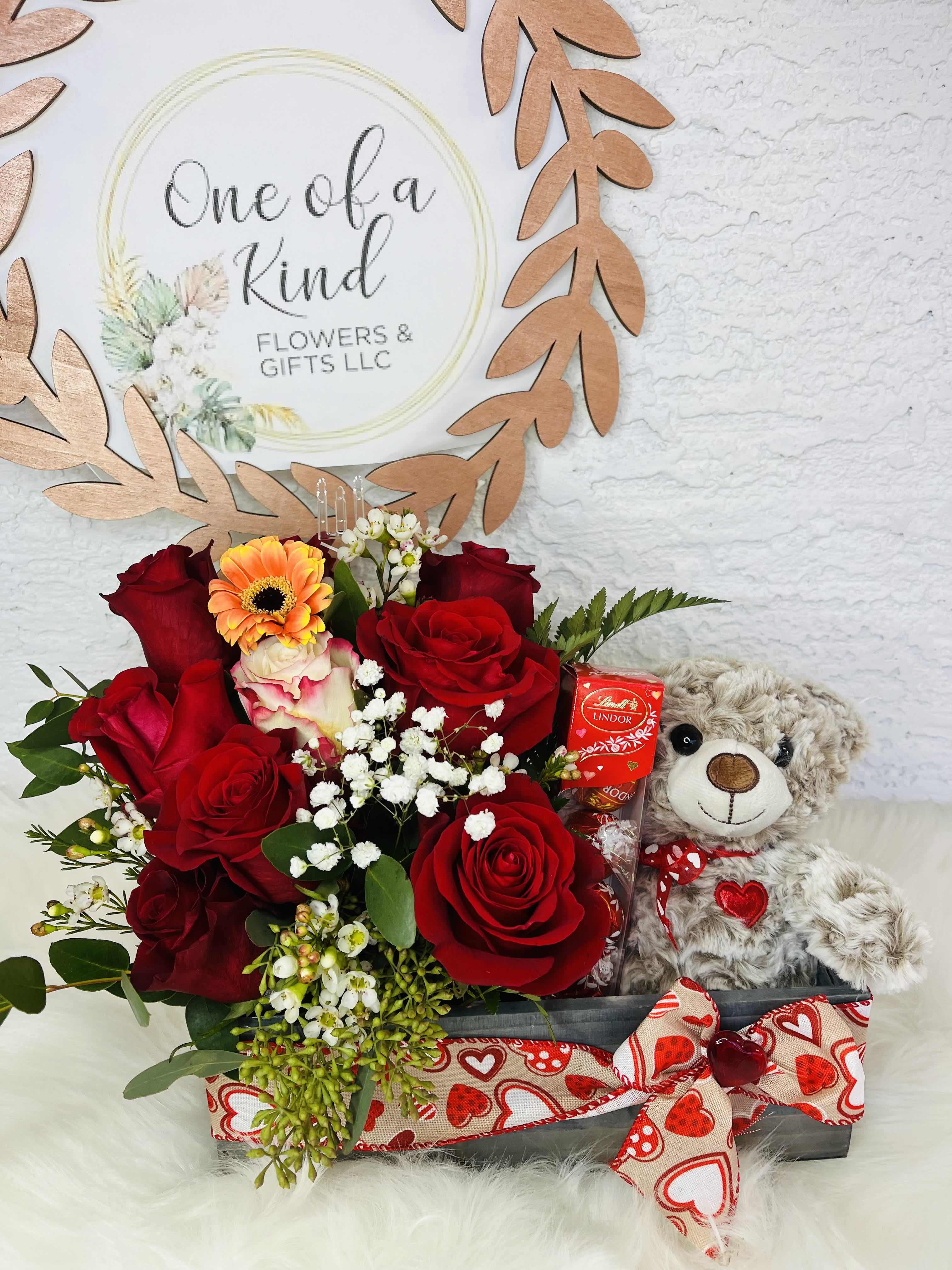 Red roses with a teddy bear and chocolates in a gift box