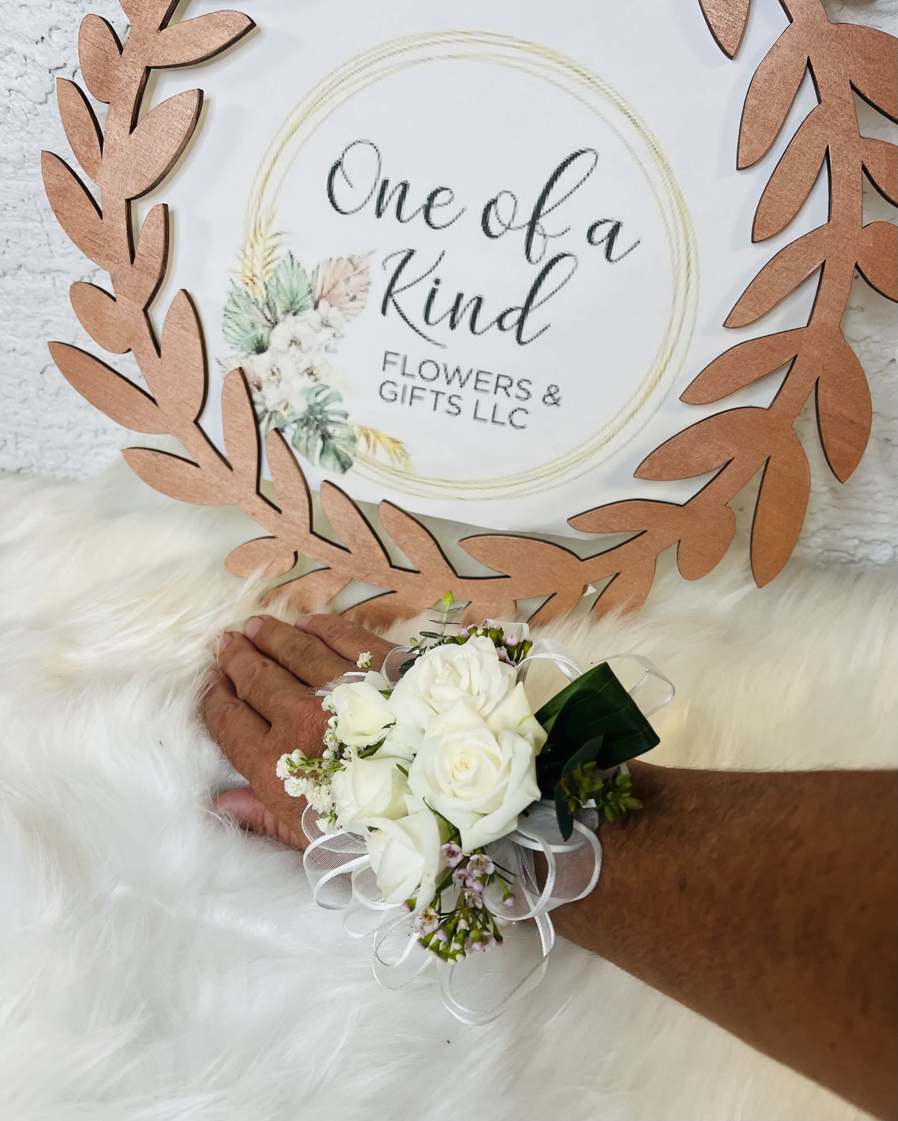White rose wrist corsage with ribbon on a person's wrist