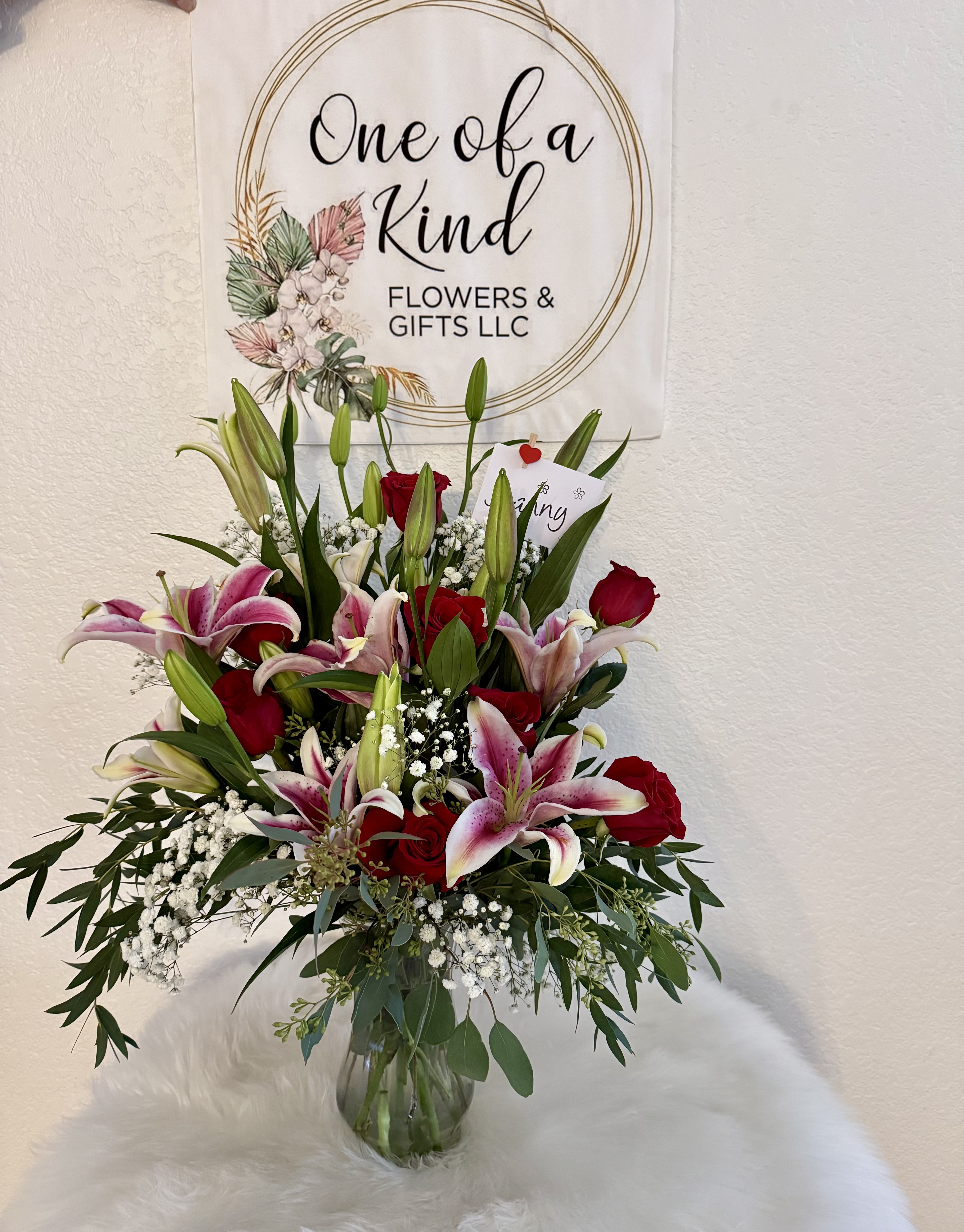 Bouquet of pink lilies and red roses in a glass vase