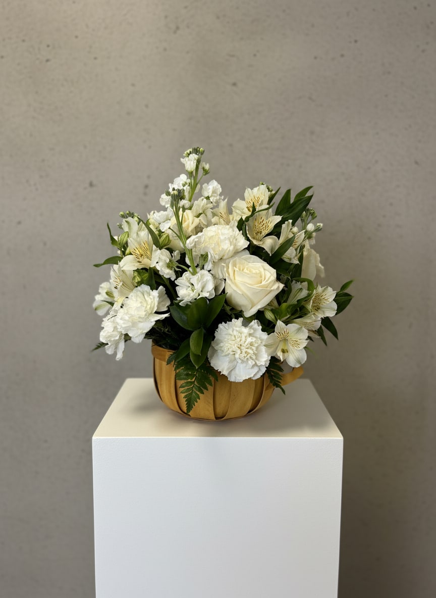 White floral arrangement in a wooden bowl on a pedestal