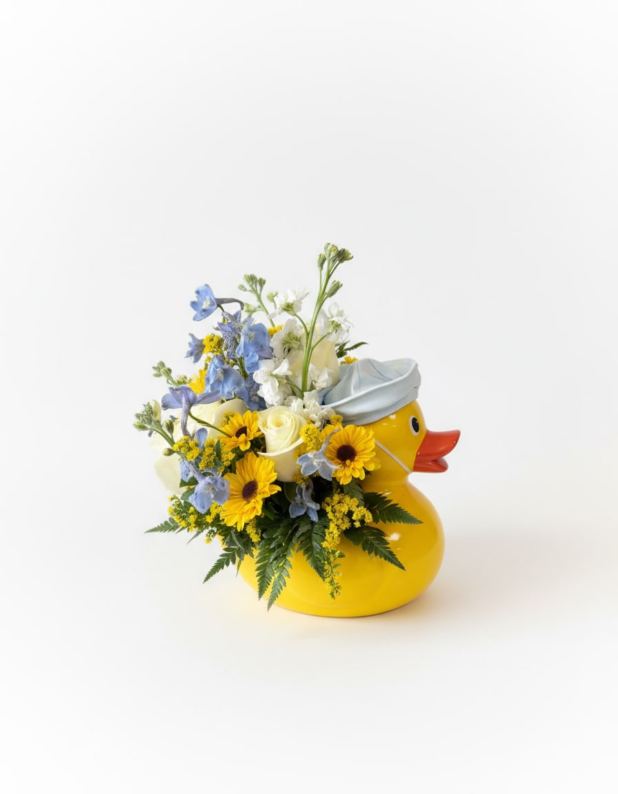 Yellow duck-shaped container holding blue, white, and yellow flowers