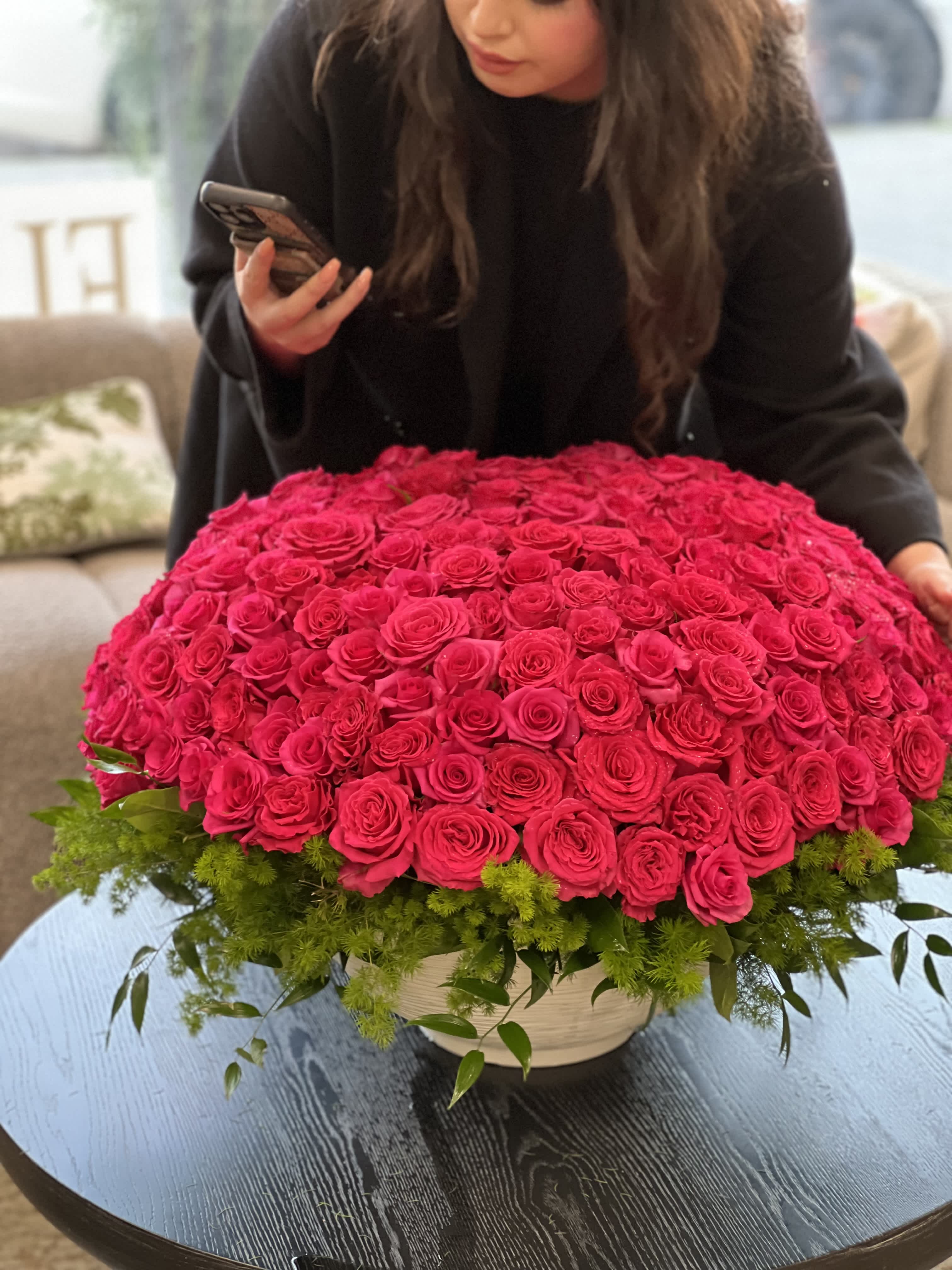 Large dome of hot pink roses in a low white container