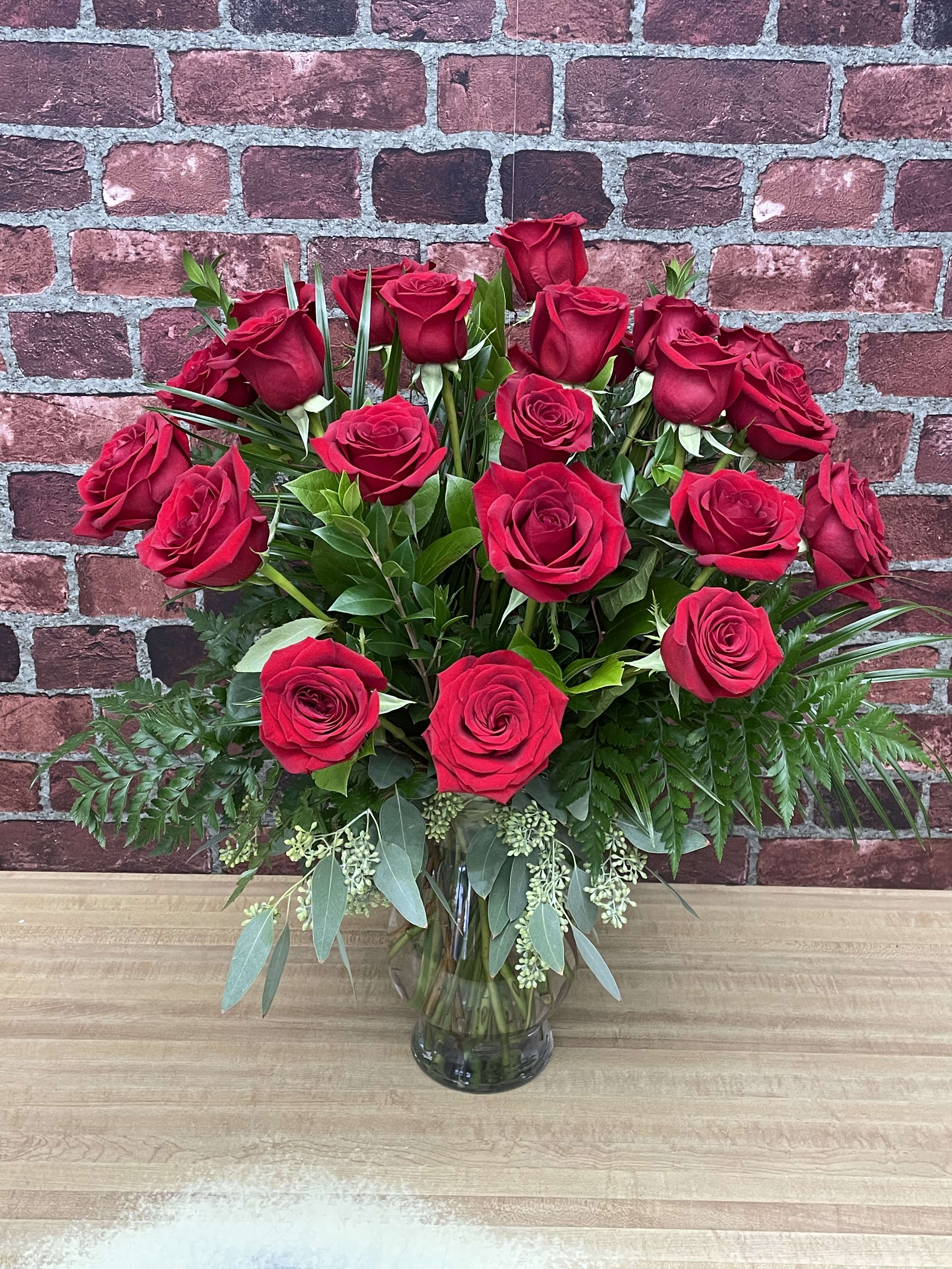 Red roses arranged in a clear glass vase