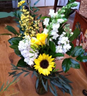 Bouquet with a sunflower, white blooms, and yellow flowers in a vase