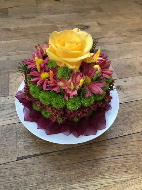 Blooming Birthday Cake - They'll never forget this incredible birthday surprise! Spray roses, pompons and mums create a fun-filled, fat-free birthday greeting. Colors will vary based on what's available. Denver Florist, LoHi Florist. Same Day Delivery if ordered before Noon Mountain Time.