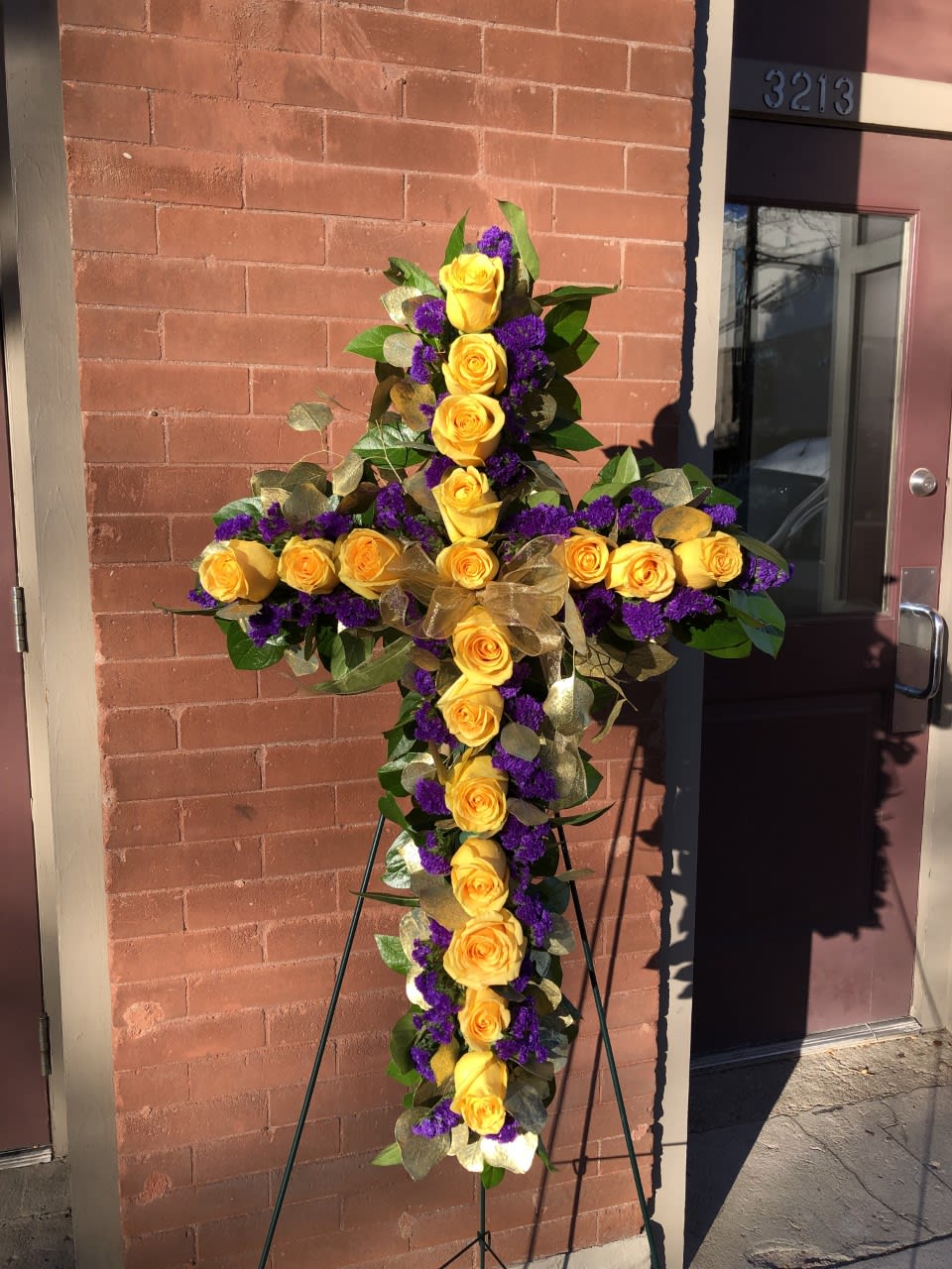 Yellow rose cross on an easel with purple accents