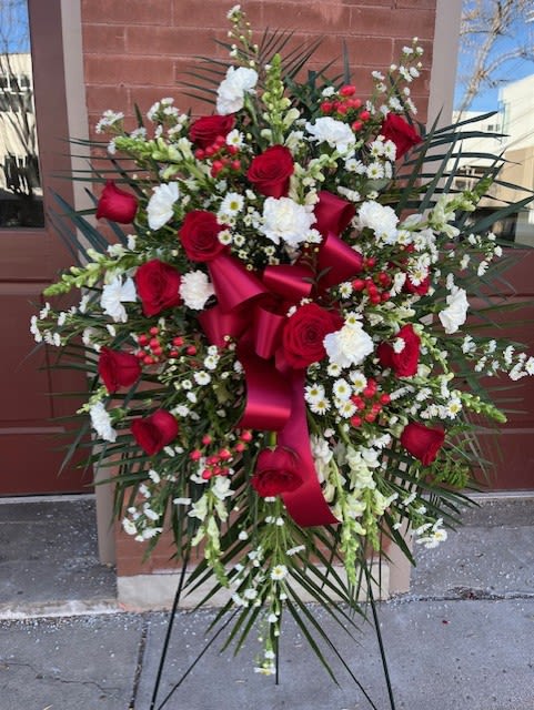 Large standing floral spray with red roses and white flowers on an easel