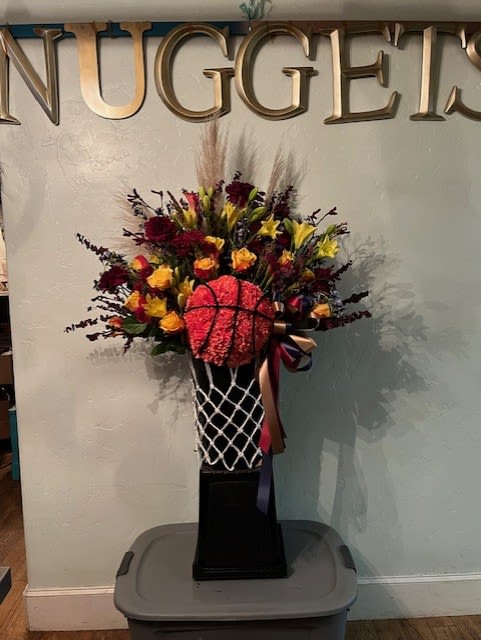Basketball-themed floral arrangement in a black pedestal vase