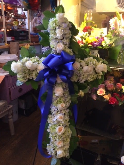 White floral cross with a blue ribbon bow