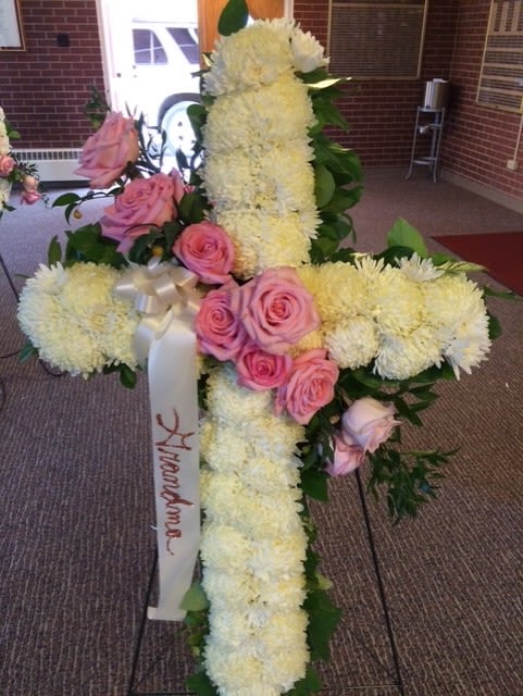 Floral cross arrangement with pink roses and white flowers