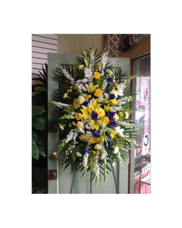 Tall standing floral spray with yellow, white, and purple flowers