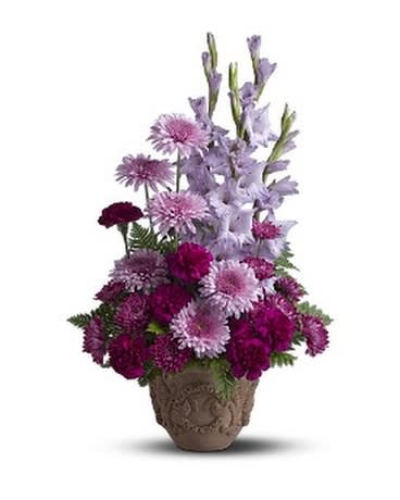 Purple and pink mixed flower arrangement in a decorative pot