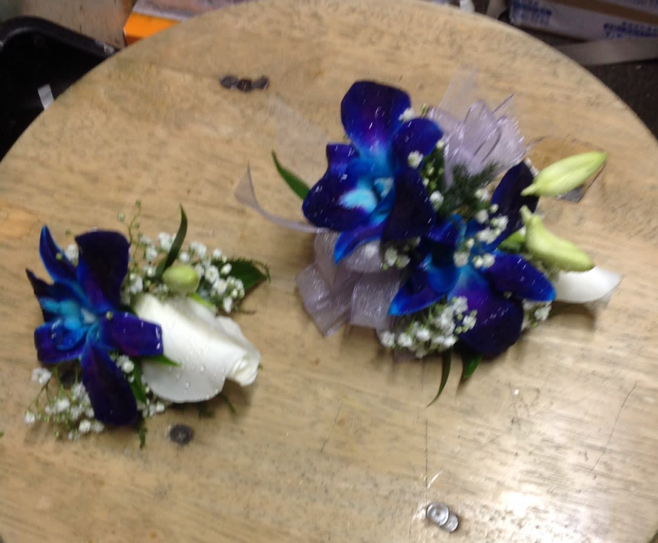 Blue and white floral corsages with ribbon accents